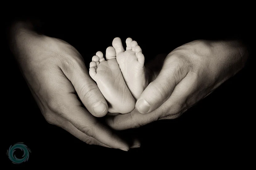 cute-photo-of-dad-holding-the-babys-feet-in-his-hands.webp