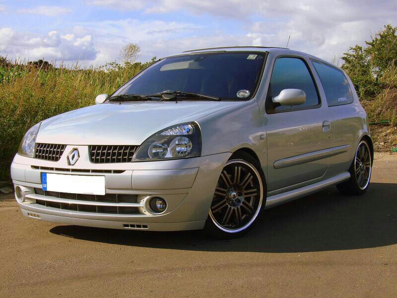 Tuned silver renault clio ii parked in front of a school on Craiyon