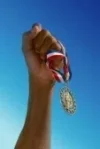 5722353-hand-holding-gold-medal.webp